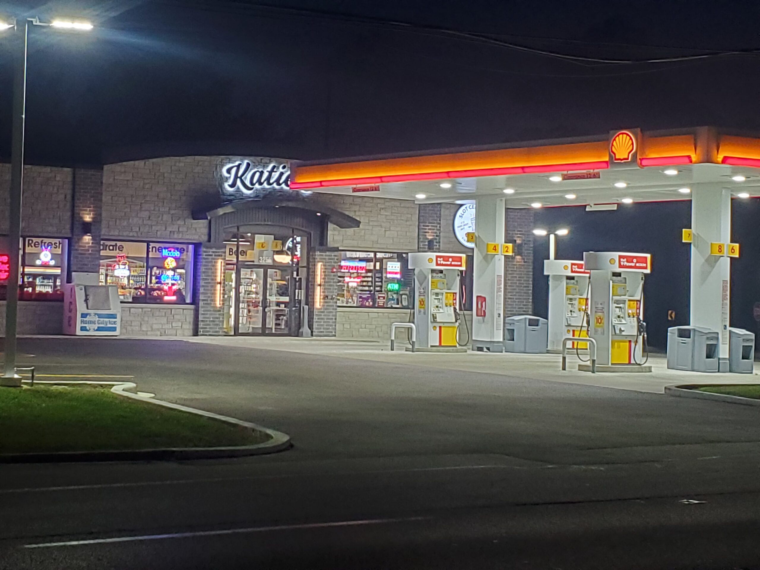 Photo of a Katie's gas station at night with bright overhead lights