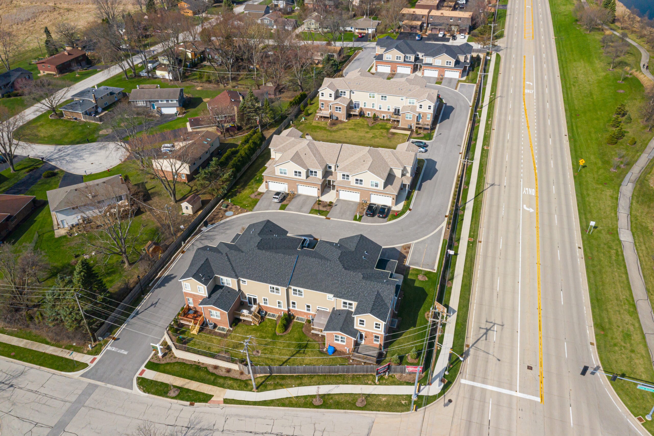 aerial view of Newberry Lane condo community that includes 4 lane street and walking paths in a green space