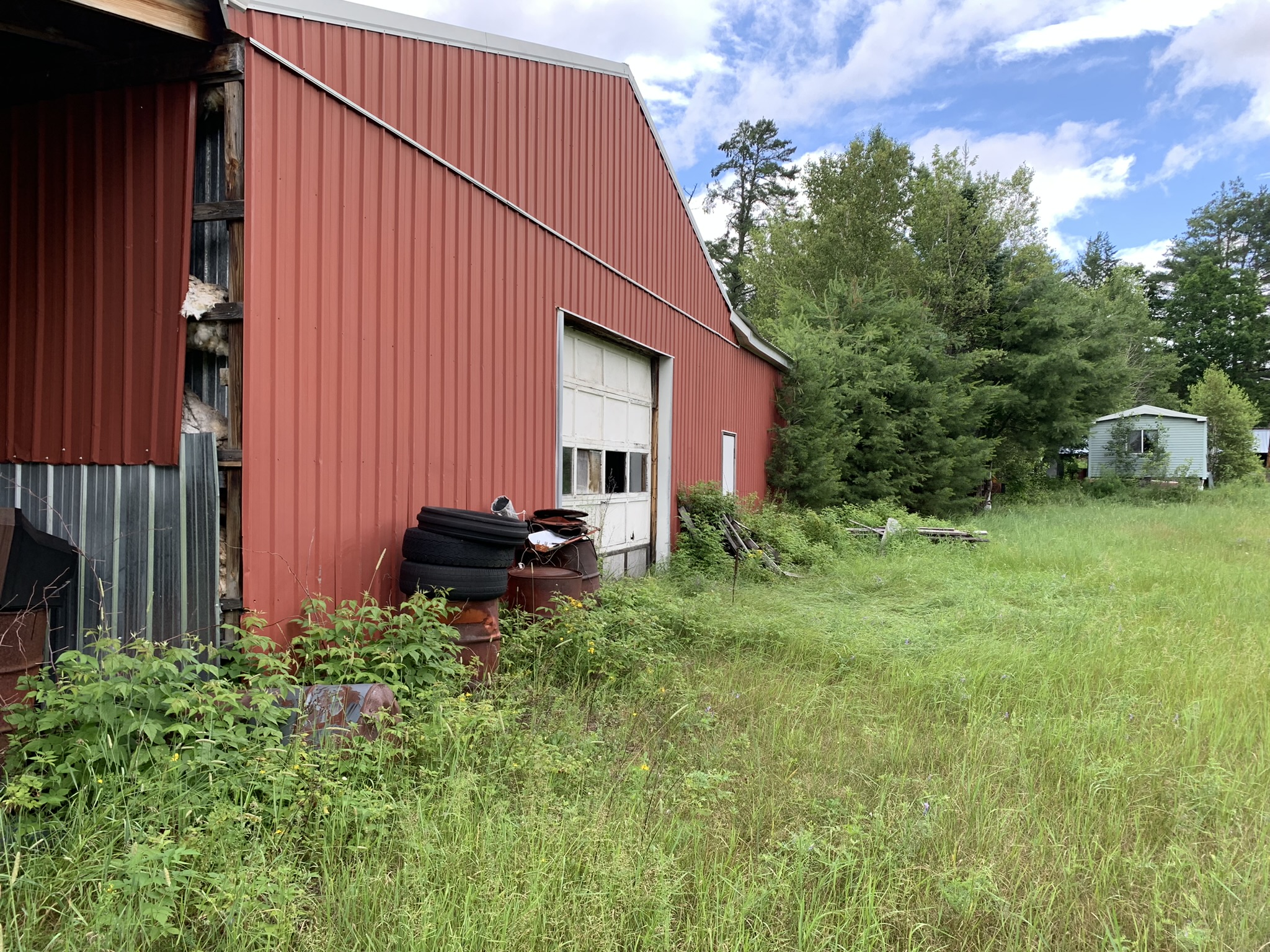 a view of the old red metal building in the middle of a Brownfields site