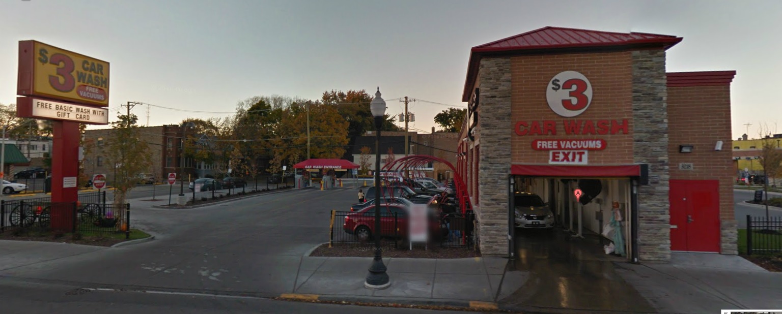 street view of the Irving Express car wash as a car prepares to exit the car wash into the street