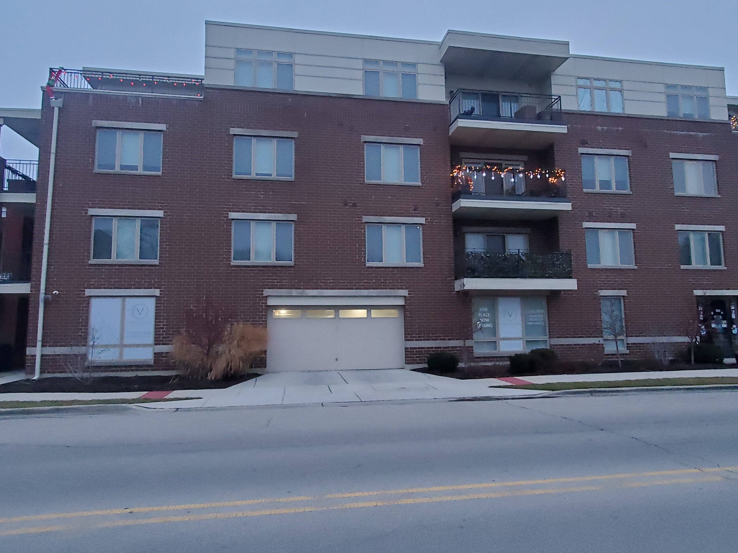 front view of a mixed use brick apartment building and lower level garage door