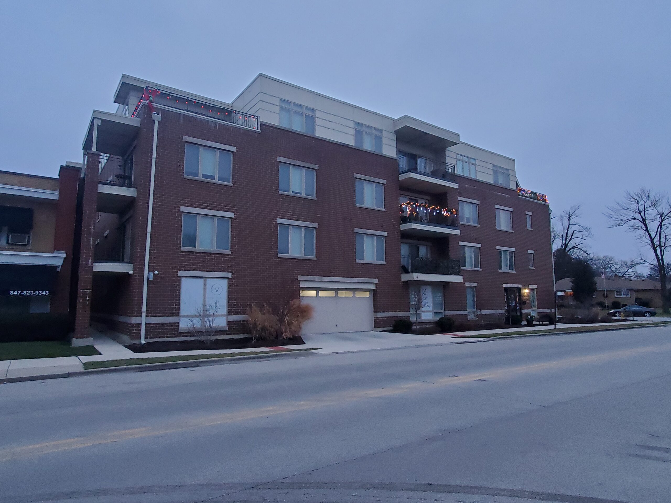 brick apartment, mixed-use building viewed from the street at dusk