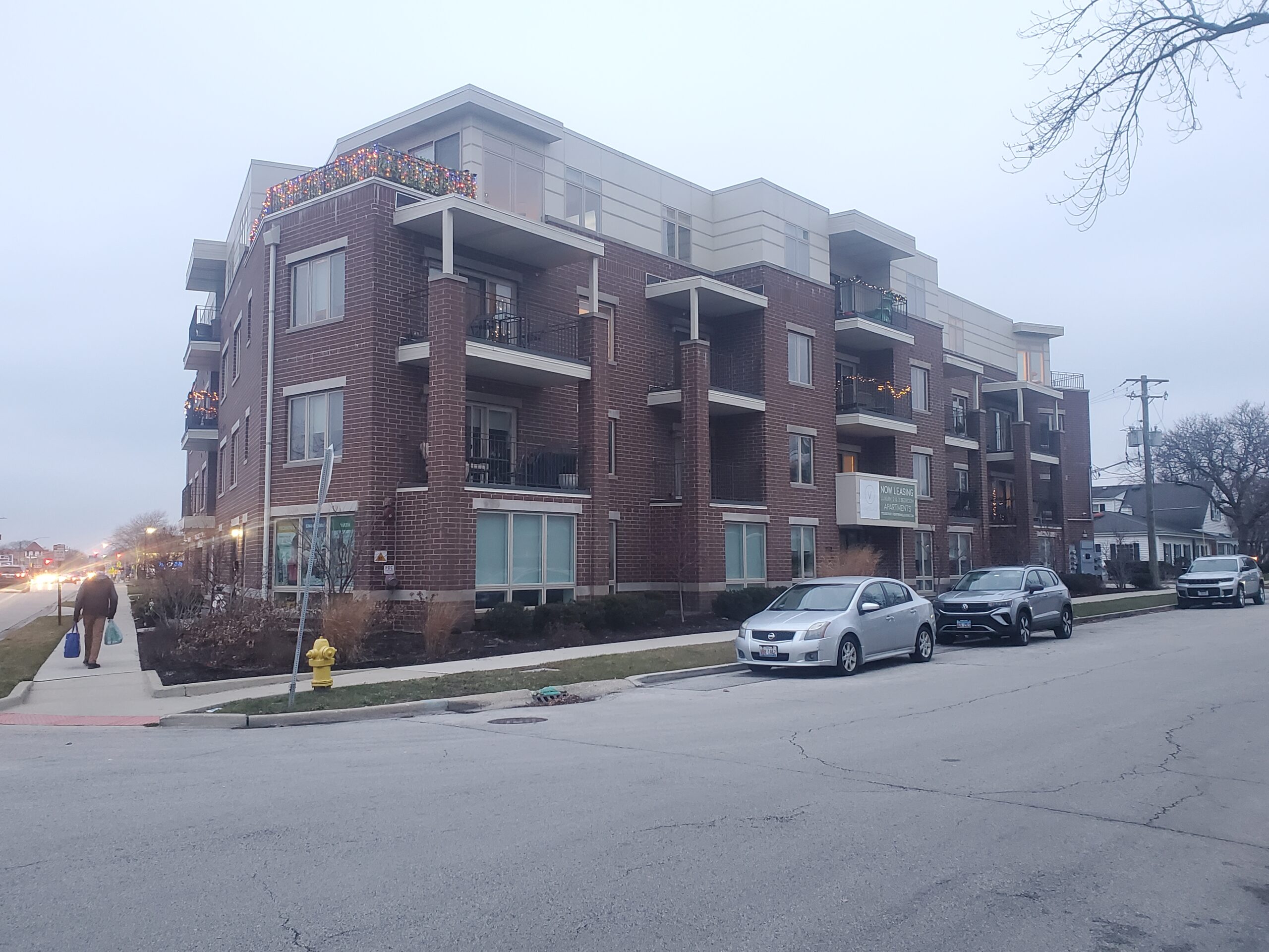 a new, brick, mixed-use building viewed diagonally from the street corner